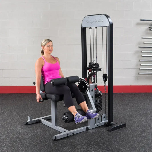 Frau trainiert an Body-Solid Kraftstation im Fitnessstudio mit Hantelbank und Kabelzug