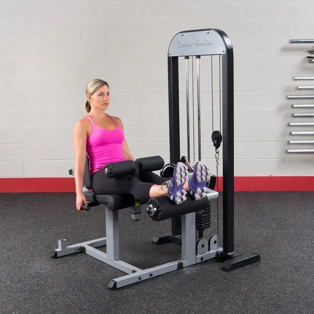 Frau trainiert Beinbeuger an Kraftstation im Fitnessstudio