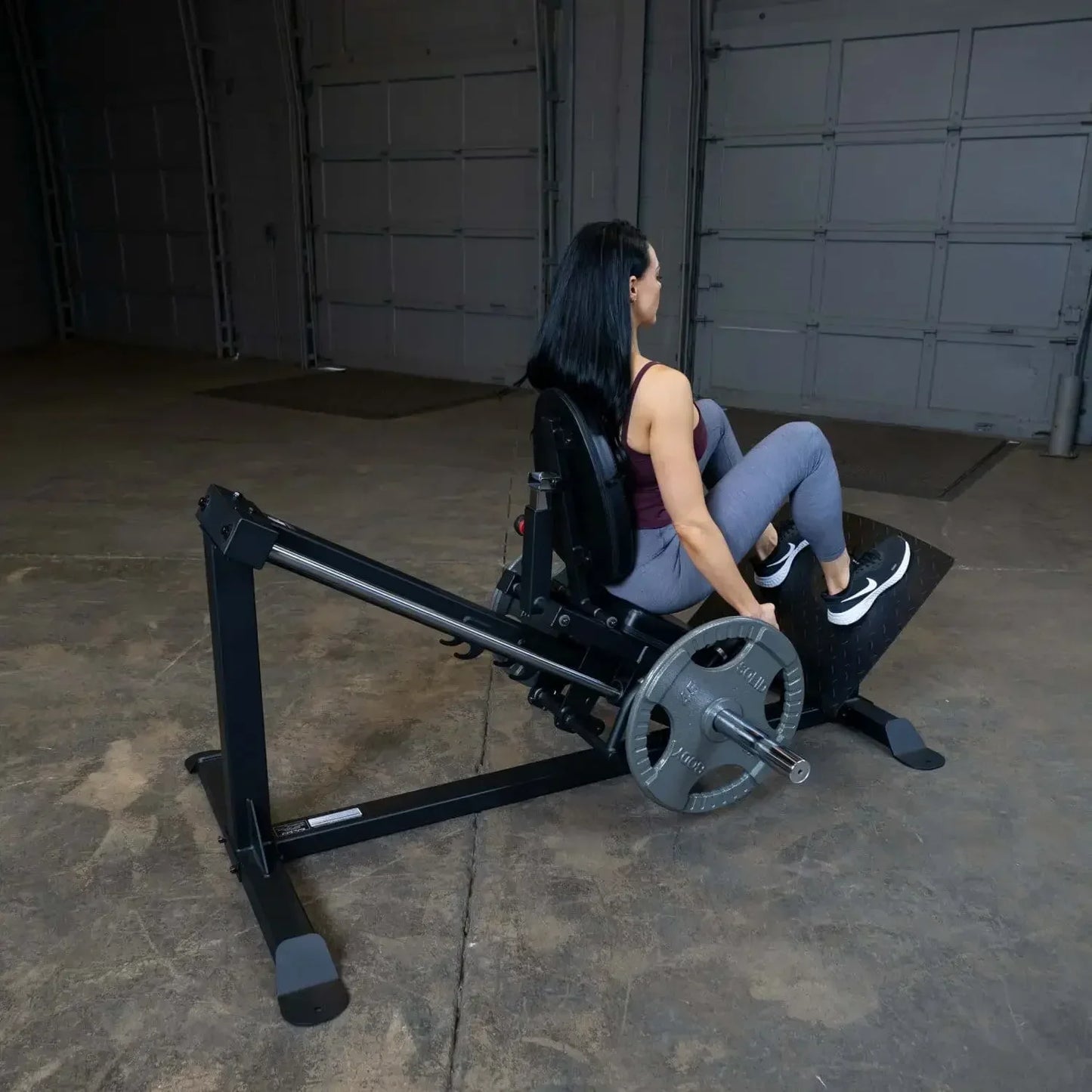 Frau trainiert auf Liegestützbank mit Gewichten im Homegym – Kraftsport & Fitness Equipment