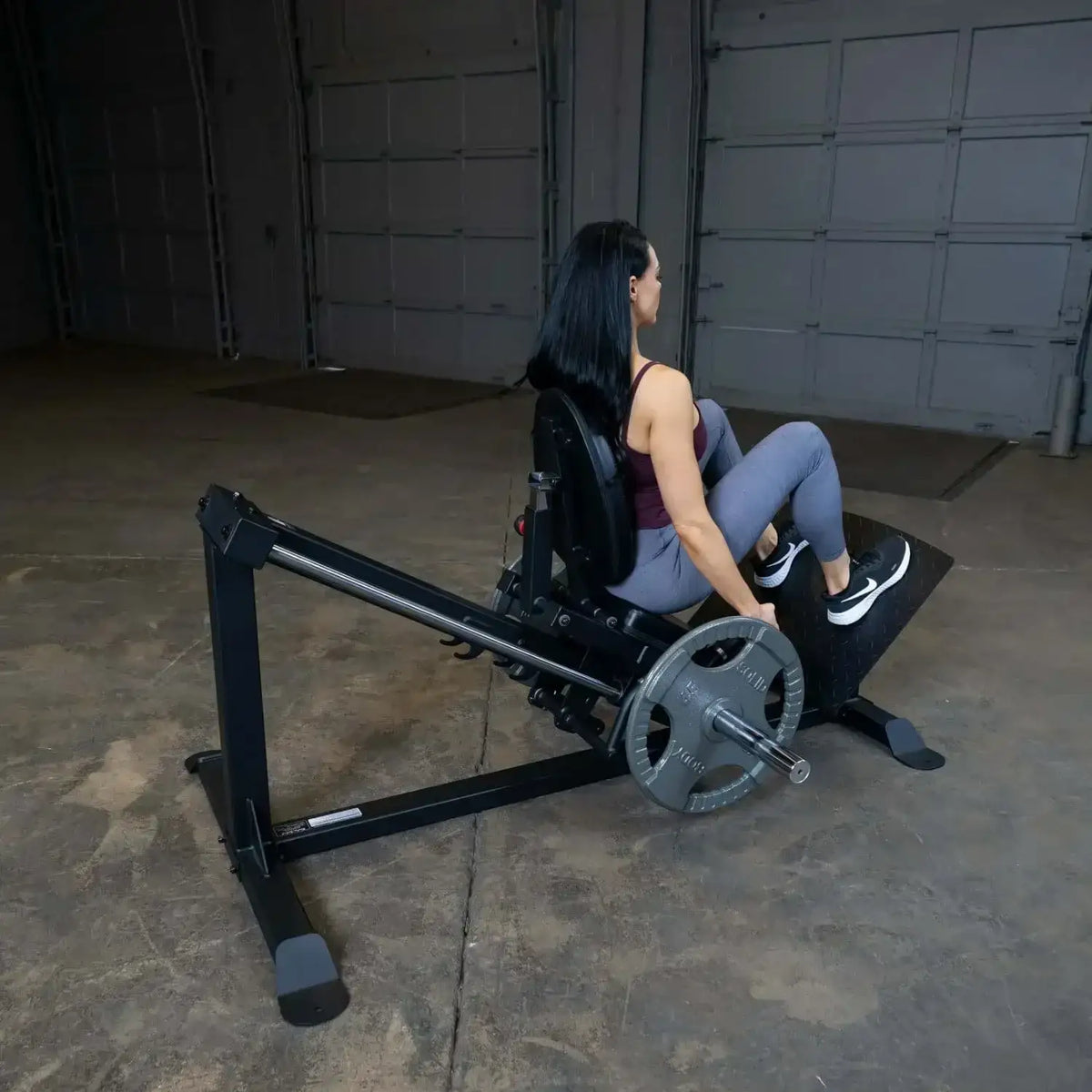 Frau trainiert auf Liegestützbank mit Gewichten im Homegym – Kraftsport & Fitness Equipment