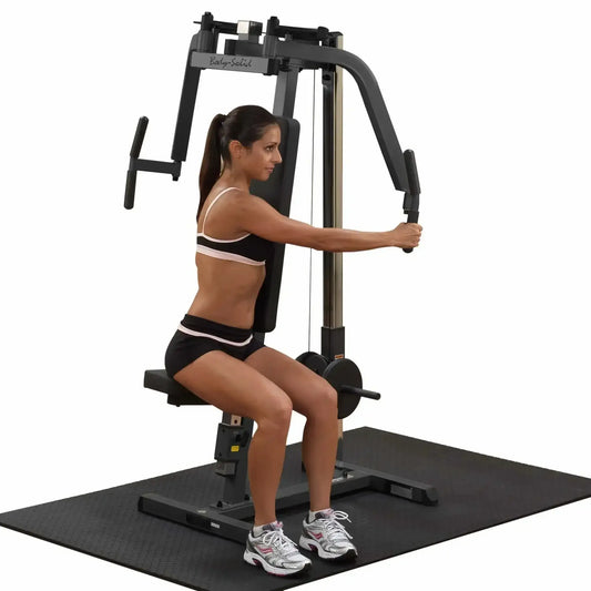 Frau trainiert an Kraftstation mit Kabelzug für Homegym oder Studio, Body-Solid