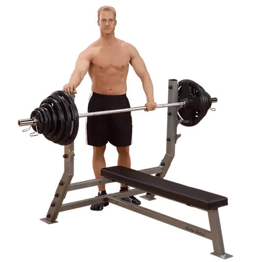 Muskulöser Mann mit Langhantel vor Hantelbank – ideales Krafttraining Equipment für Homegym & Studio