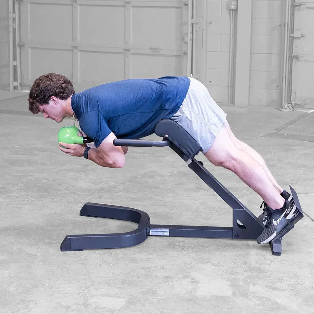 Mann trainiert mit Kettlebell auf Rückenbank für Homegym & Studio Fitness
