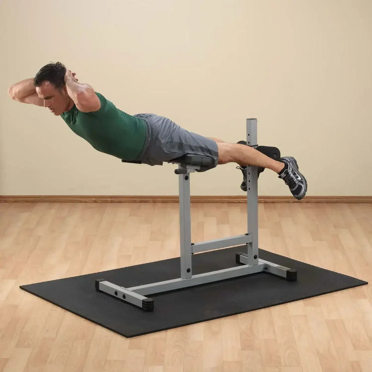 Mann trainiert Bauchmuskeln auf Hantelbank im Homegym mit Fitnessmatte