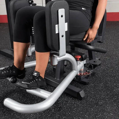 Frau trainiert Beine an Kraftstation im Fitnessstudio – ideales Homegym Equipment für Kraftsport