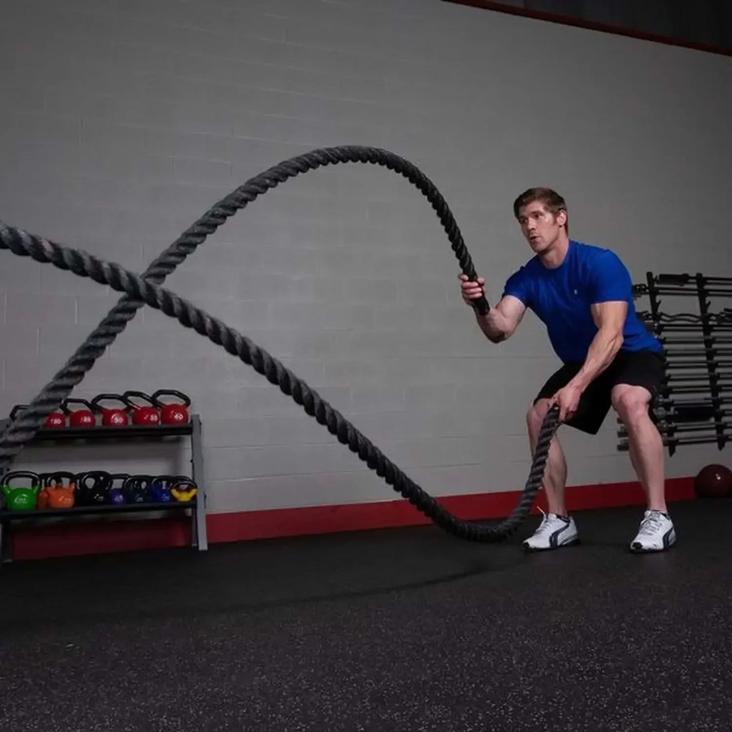 Mann trainiert mit Battle Ropes im Fitnessstudio, Kraftsport & Functional Training