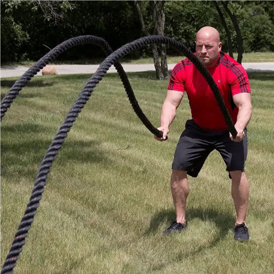 Muskulöser Mann trainiert mit Battle Ropes im Freien – Fitness & Krafttraining Equipment