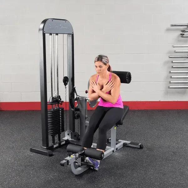 Frau trainiert an Kraftstation im Fitnessstudio mit Hantelbank und Kabelzug