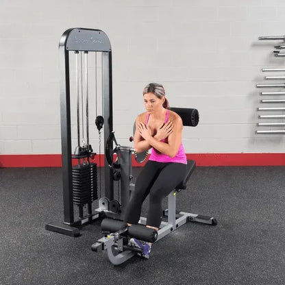 Frau trainiert an Kraftstation im Fitnessstudio mit Hantelbank und Kabelzug
