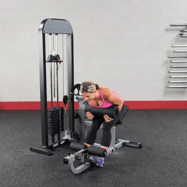 Frau trainiert Rücken an Kraftstation im Fitnessstudio mit Hantelbank und Gewichten