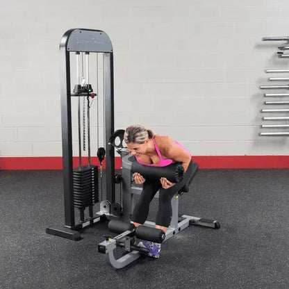 Frau trainiert Rücken an Kraftstation im Fitnessstudio mit Hantelbank und Gewichten