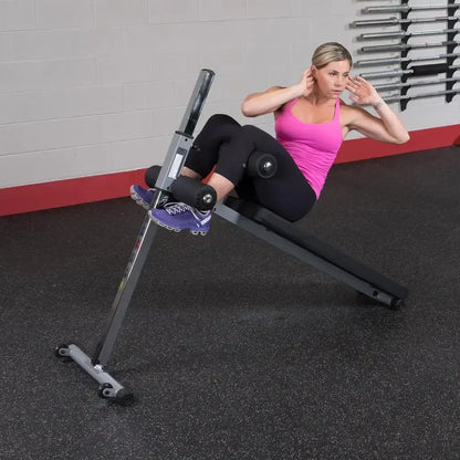 Frau trainiert Bauchmuskeln auf Hantelbank im Fitnessstudio mit Kraftsport-Equipment