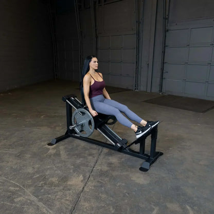 Frau trainiert Beine mit Beinpresse im Fitnessstudio, Kraftstation für Homegym & Studio