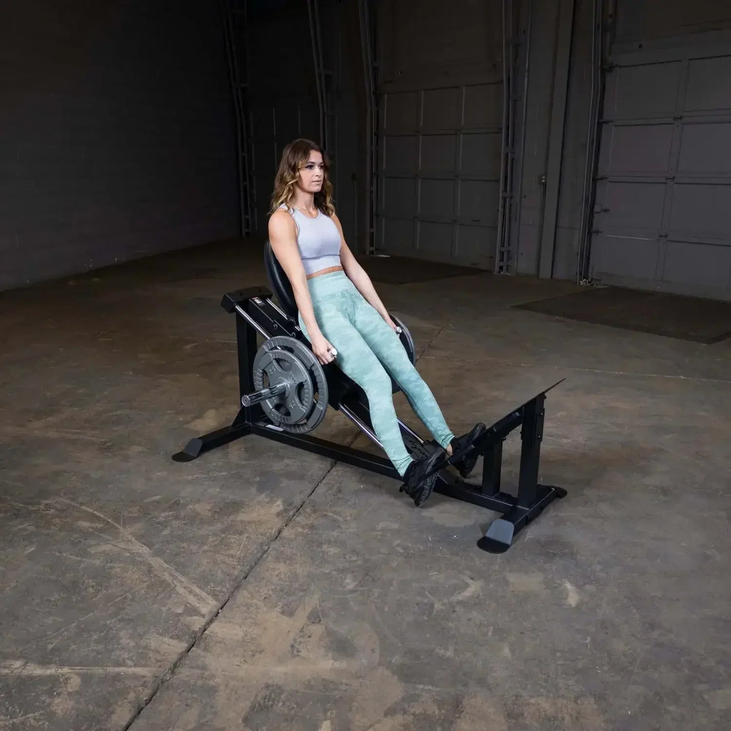 Frau trainiert auf einer Beinpresse im Fitnessstudio – ideales Krafttraining für Beine und Po
