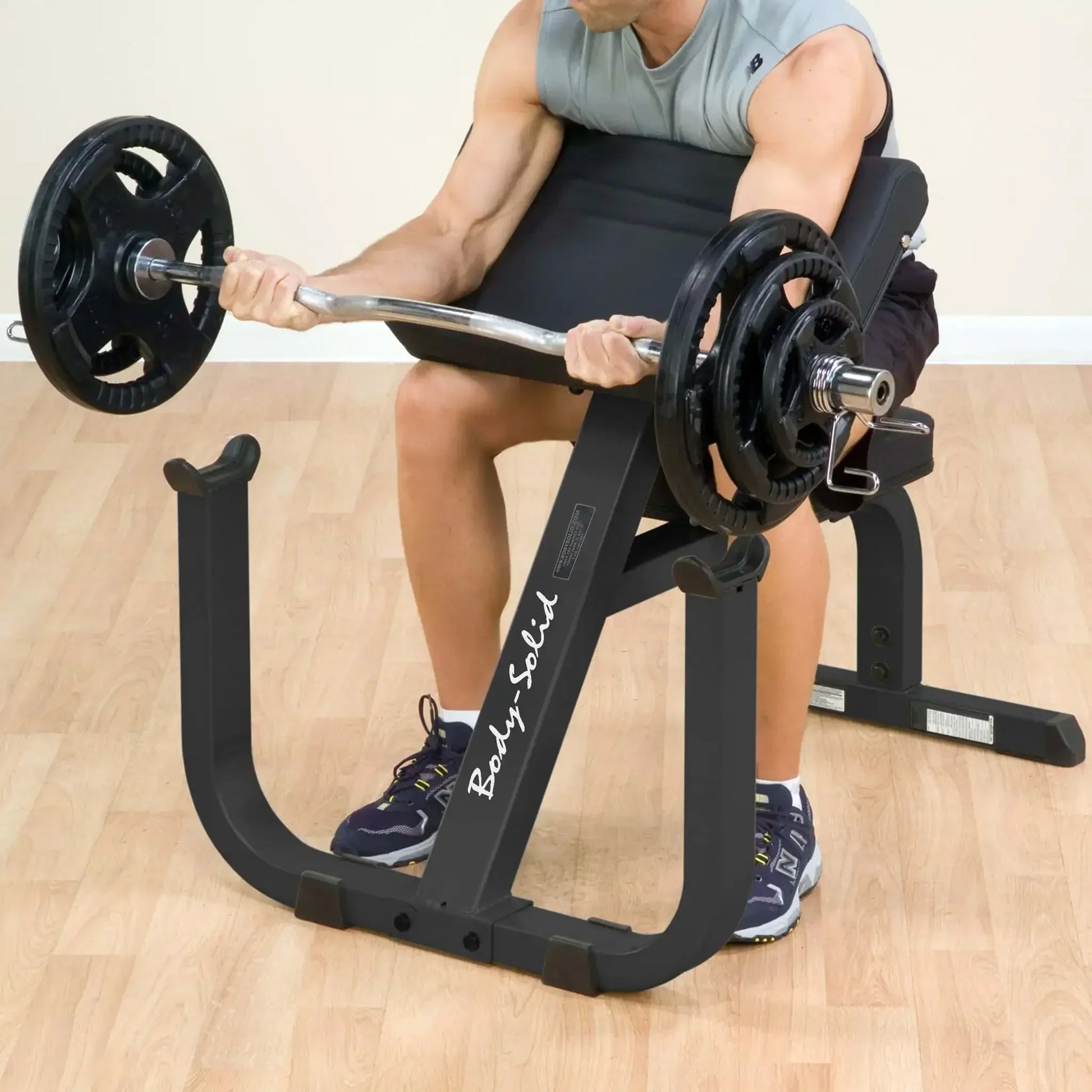 Mann trainiert Bizeps mit Kurzhantelbank und EZ-Bar im Homegym