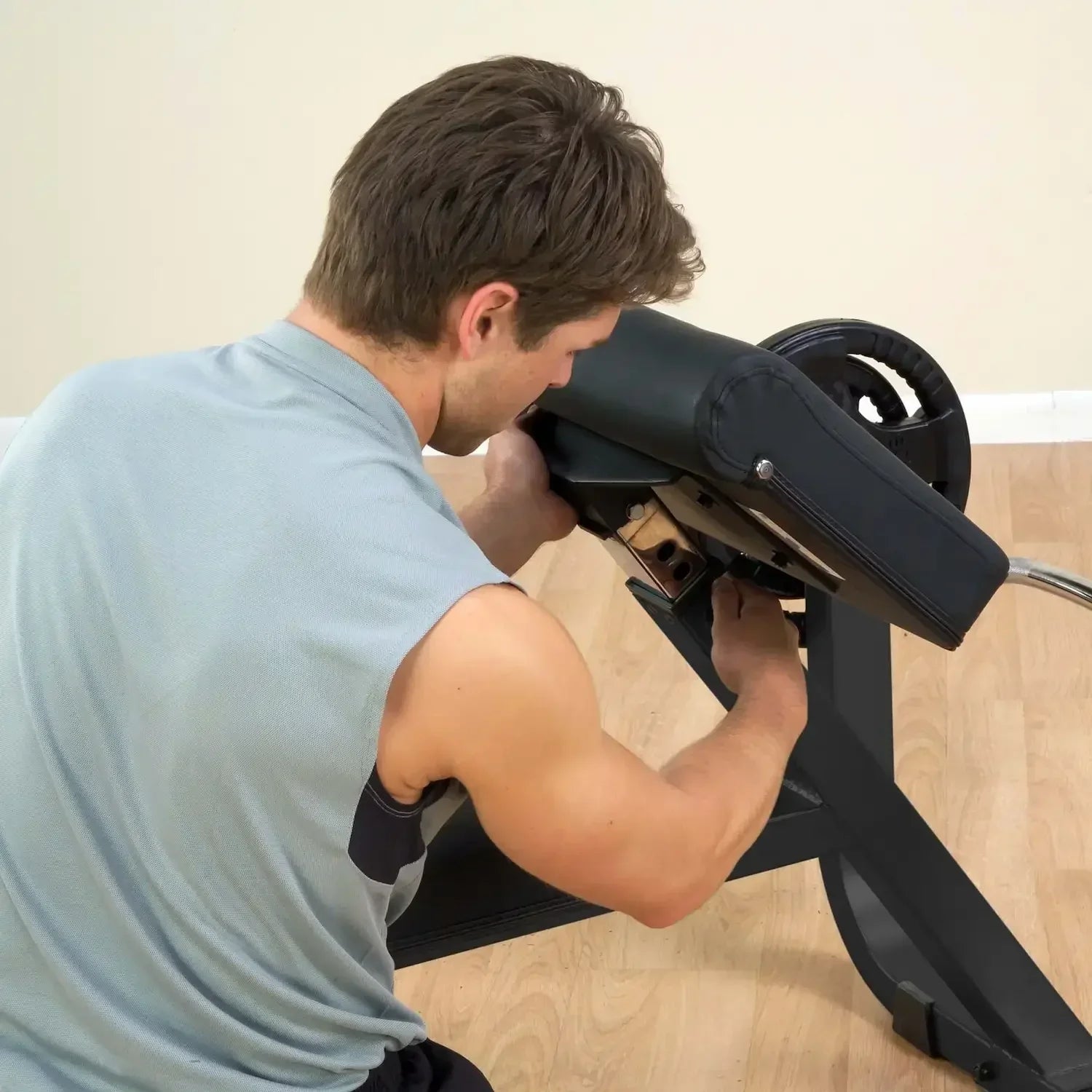 Mann trainiert mit Fitness-Kraftgerät für Bizepsübungen im Homegym