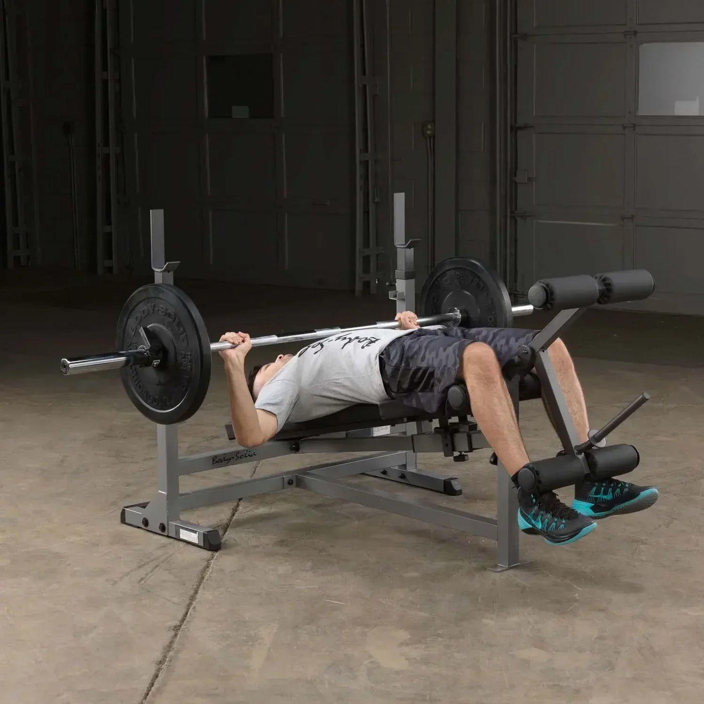 Mann trainiert Bankdrücken auf Hantelbank mit Barbell im Homegym – Kraftsport Equipment