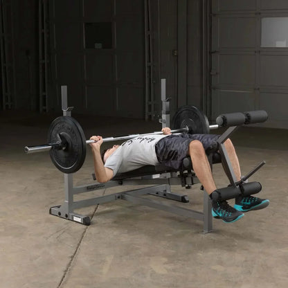 Mann trainiert Bankdrücken auf Hantelbank mit Barbell im Homegym – Kraftsport Equipment