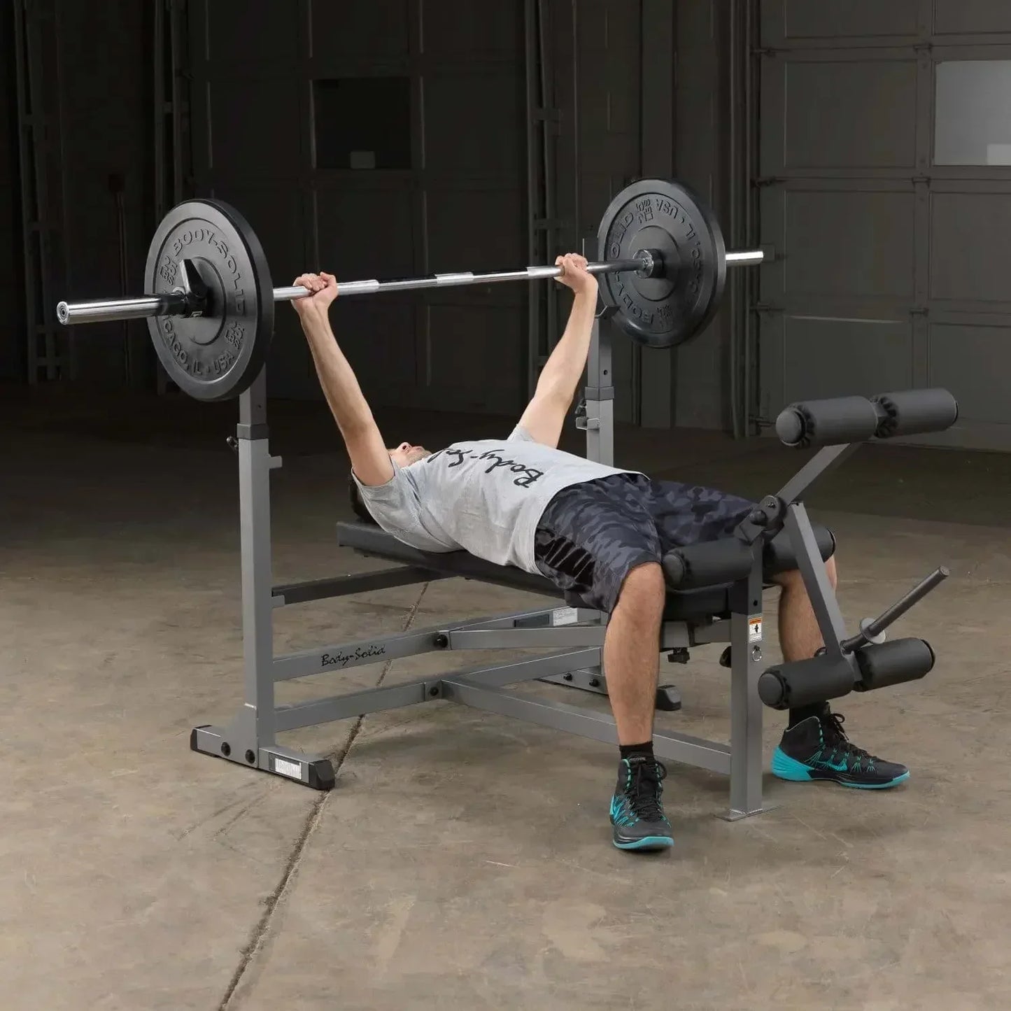 Mann trainiert Bankdrücken auf Hantelbank mit Barbell im Homegym