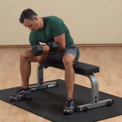 Mann trainiert mit Hanteln auf Hantelbank im Homegym – Fitness-Kraftgeräte für effektives Krafttraining