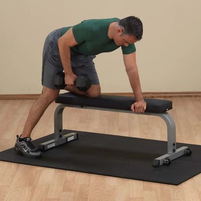 Mann trainiert mit Hanteln auf Hantelbank im Homegym – Fitness-Kraftgeräte für effektives Krafttraining