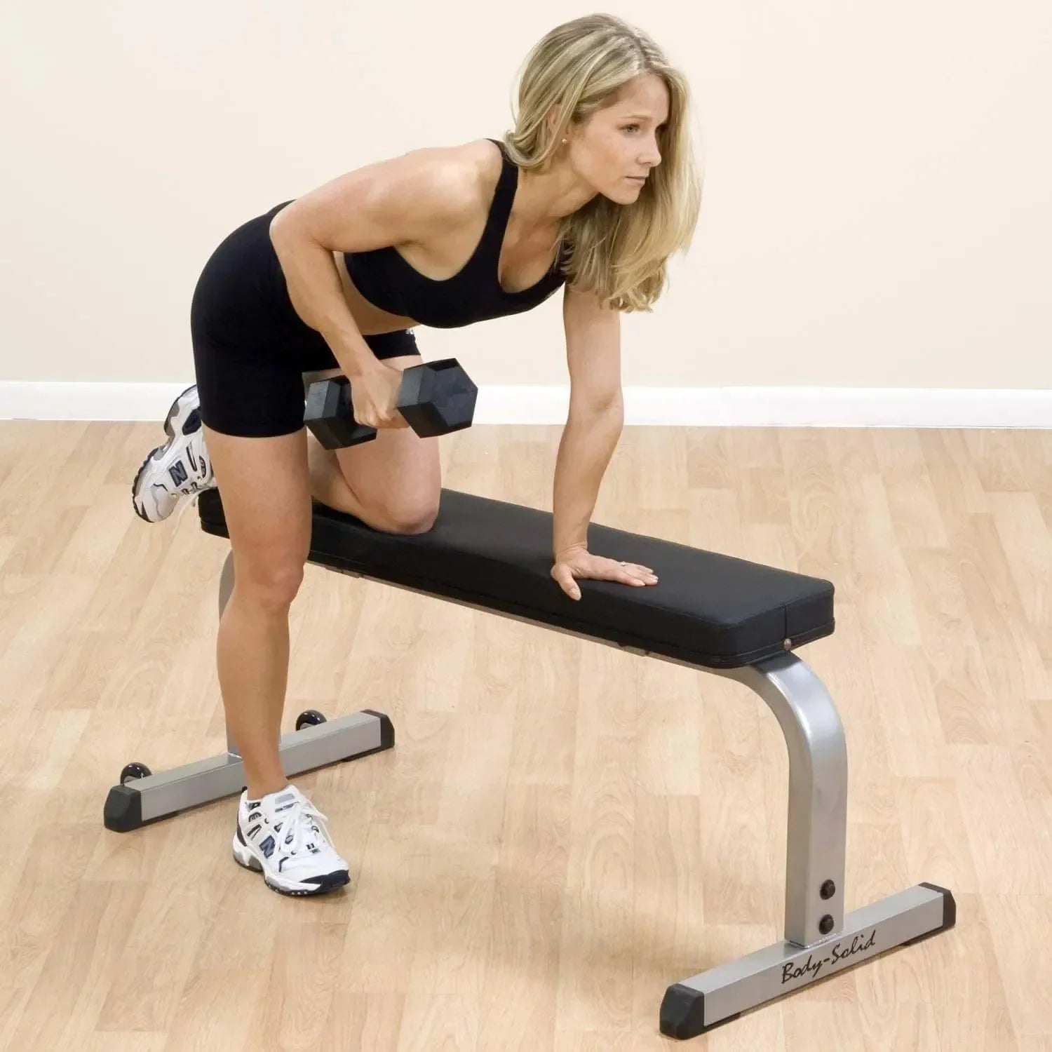 Frau trainiert mit Hanteln auf Hantelbank für Homegym und Fitnessstudio