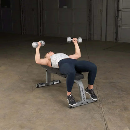 Frau trainiert mit Hanteln auf Hantelbank im Homegym – Kraftsport & Fitness Equipment