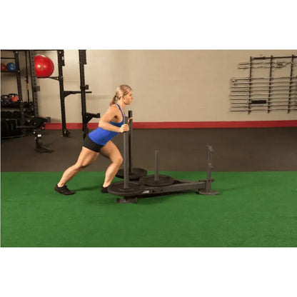 Frau trainiert mit Gewichtsschlitten im Fitnessstudio – Krafttraining für Beine und Core