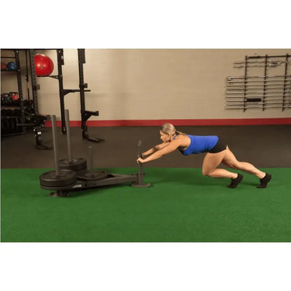 Frau trainiert mit Gewichtsscheiben auf Fitnessgerät im Studio – Krafttraining & Fitness-Equipment