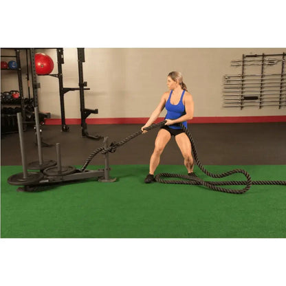 Frau trainiert mit Battle Rope im Fitnessstudio, Krafttraining mit Seil und Gewichten