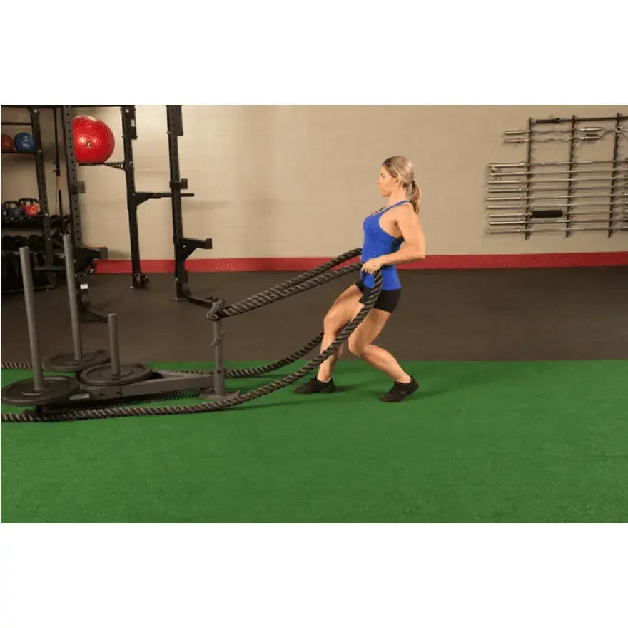 Frau trainiert mit Battle Ropes in Fitnessstudio, Kraftsport & Functional Training Equipment