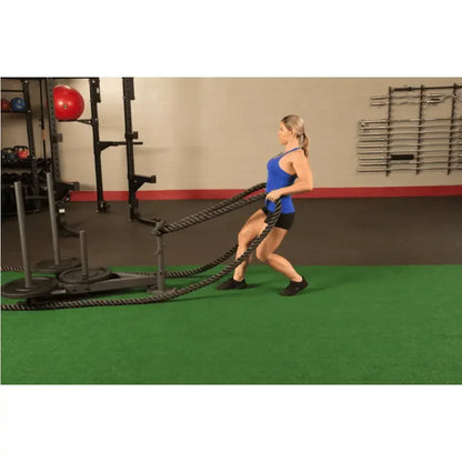 Frau trainiert mit Battle Ropes in Fitnessstudio, Kraftsport & Functional Training Equipment