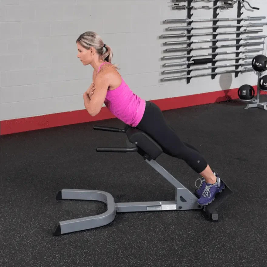 Frau trainiert Rücken auf Hantelbank im Fitnessstudio – ideales Equipment für Homegym & Studio
