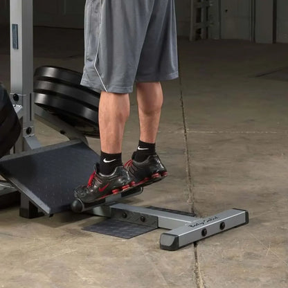 Mann trainiert Beine auf Fitness-Stepper mit Hantelbank im Homegym