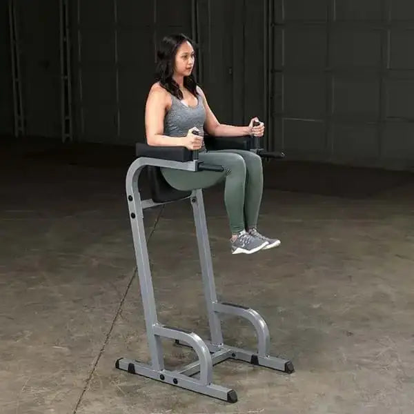 Frau trainiert an einer Fitness-Kraftstation mit gepolstertem Sitz und Griffen für Krafttraining zu Hause