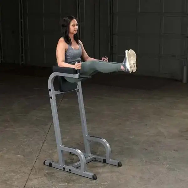 Frau trainiert Bauchmuskeln auf Fitness-Hantelbank im Homegym mit Kraftstation