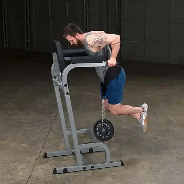 Mann trainiert Rücken mit Klimmzugstation und Gewicht im Homegym