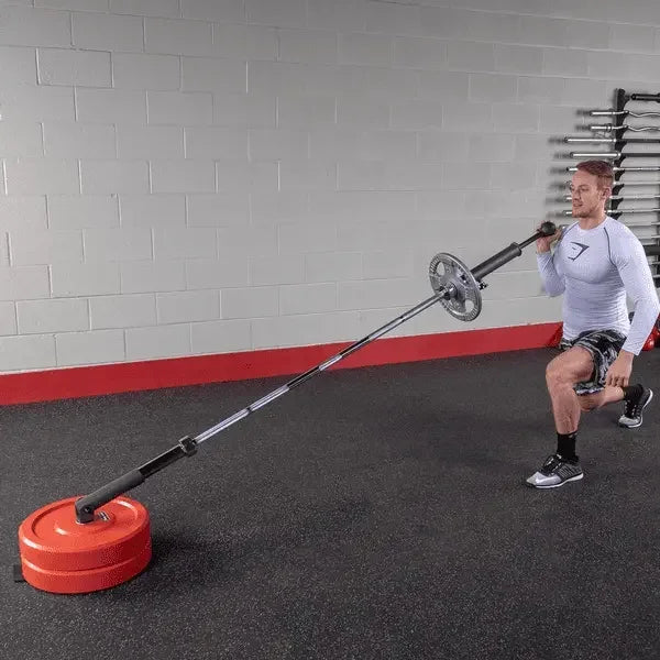 Mann trainiert mit Langhantel und roten Gewichten im Fitnessstudio – Krafttraining Equipment