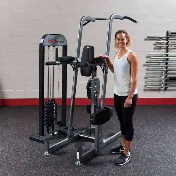 Frau neben multifunktionaler Kraftstation mit Kabelzug und Gewichtsscheiben im Fitnessstudio