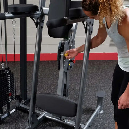 Frau justiert Gewicht an Kraftstation im Fitnessstudio – ideal für Homegym & Studio-Training