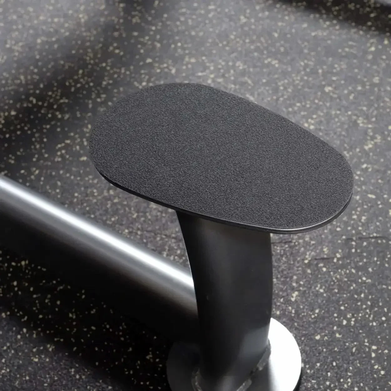 Schwarzer gepolsterter Armlehnenkissen für Fitnessgeräte auf Gummi-Boden