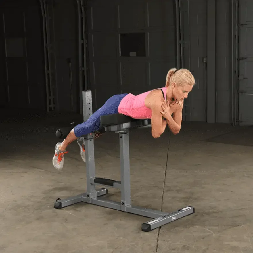Frau trainiert Rückenübungen auf Hantelbank im Homegym – Fitness-Kraftgeräte für effektives Training