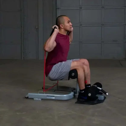 Mann trainiert mit Kraftstation und Widerstandsbändern im Homegym – Fitness-Kraftgeräte für effektives Training
