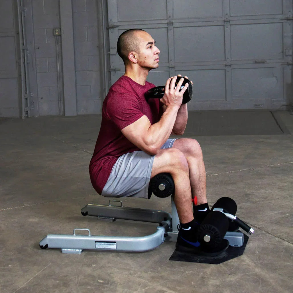Mann trainiert mit Kettlebell auf Hantelbank im Fitnessstudio