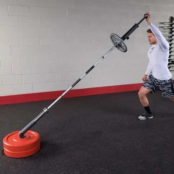 Mann trainiert mit Langhantel und roten Gewichten im Fitnessstudio