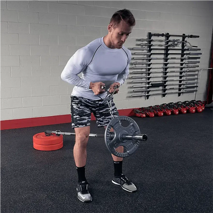 Mann trainiert mit Hantel und Ketten im Fitnessstudio – Kraftsport Equipment für Homegym & Studio