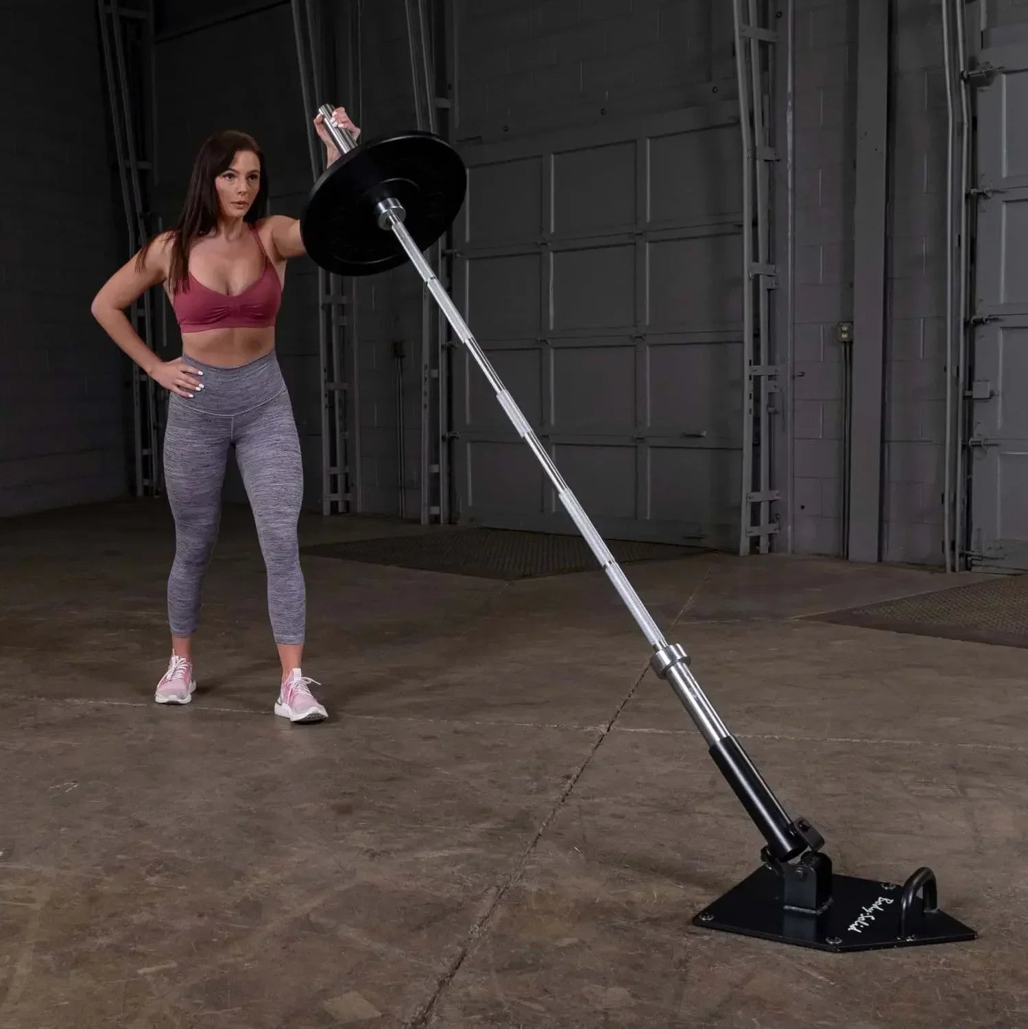 Frau trainiert mit Langhantel an Kraftstation im Fitnessstudio, ideal für Homegym & Studio