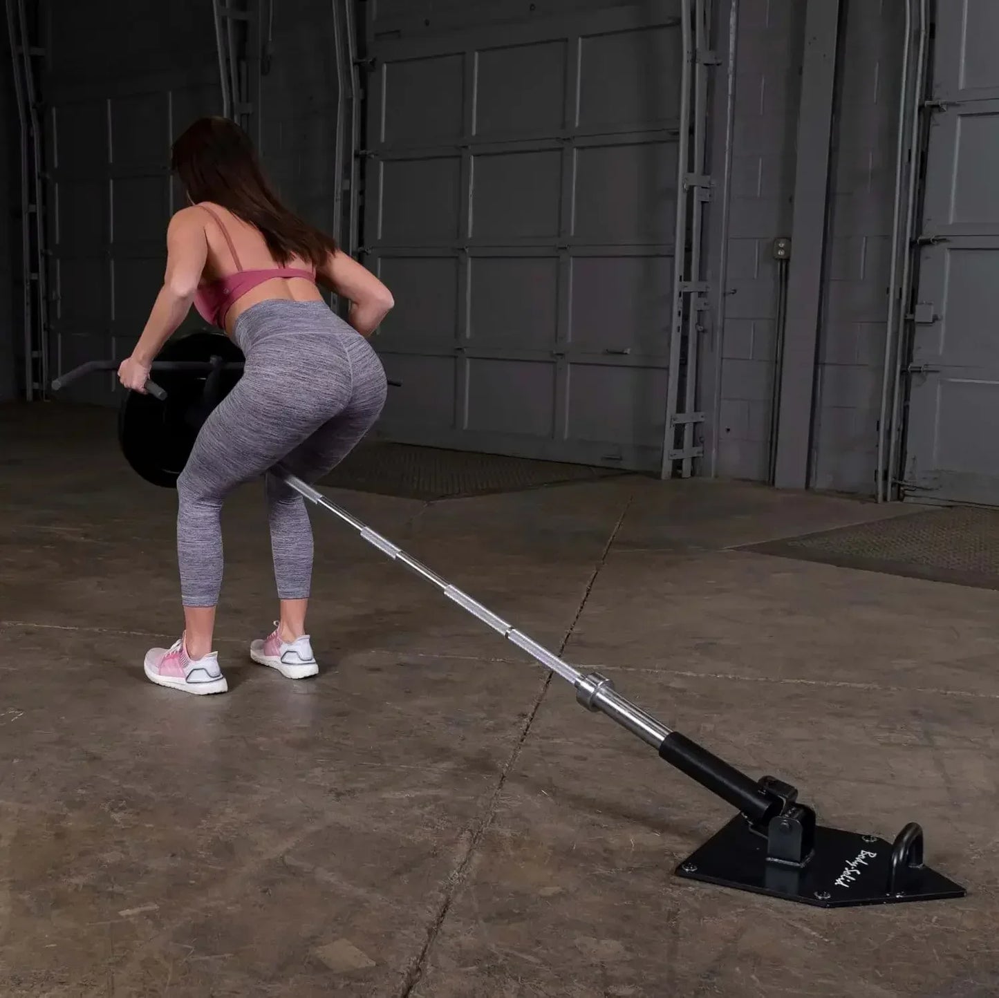 Frau trainiert mit Langhantel an Kraftstation im Homegym – Fitness & Kraftsport Equipment