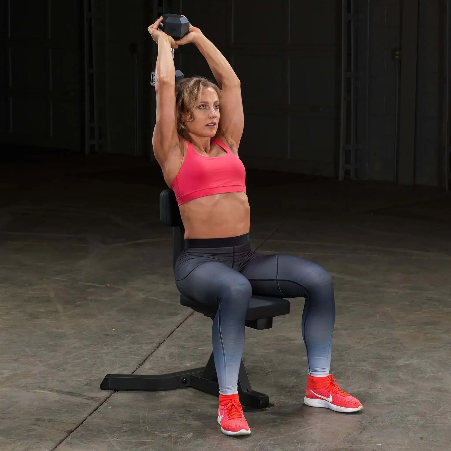 Frau trainiert mit Hantel auf Fitnessbank – Krafttraining zu Hause oder im Studio