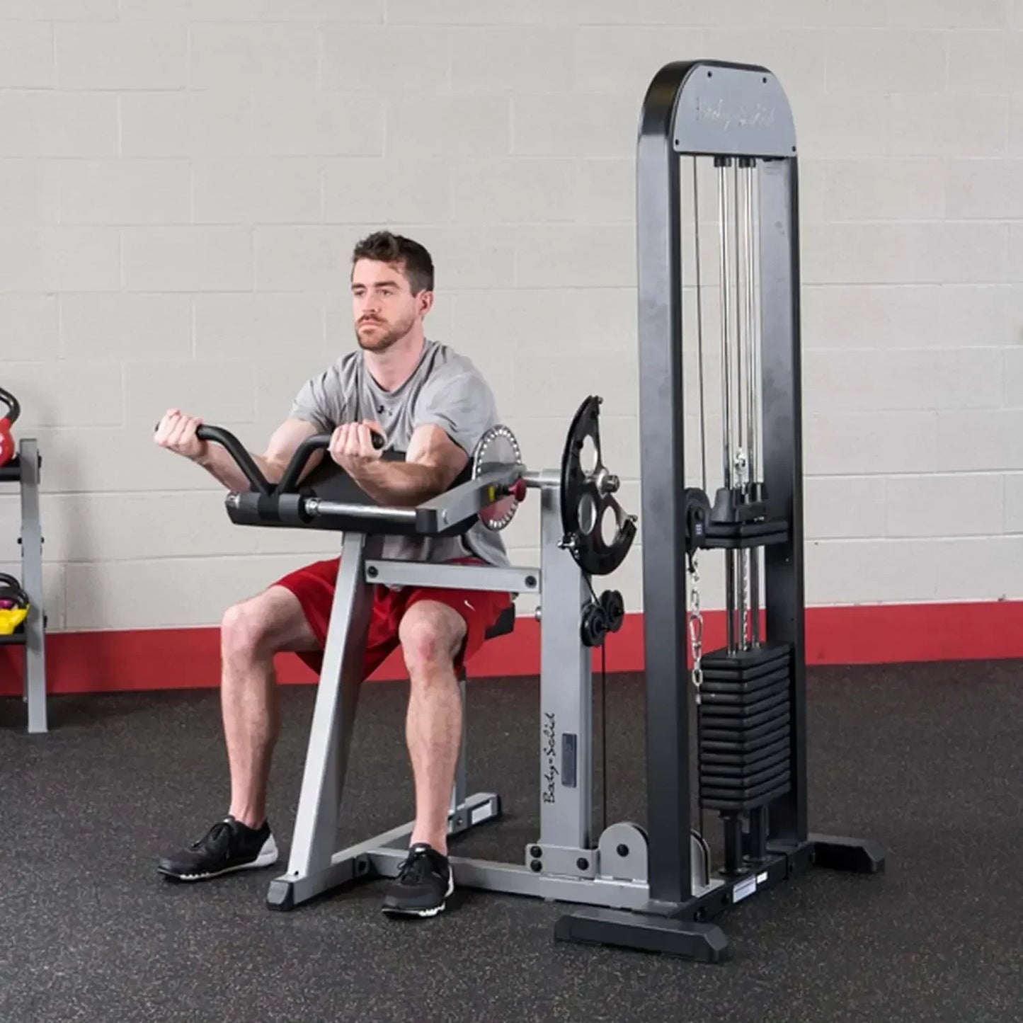 Mann trainiert an einer Kraftstation im Fitnessstudio – ideales Equipment für Homegym & Studio